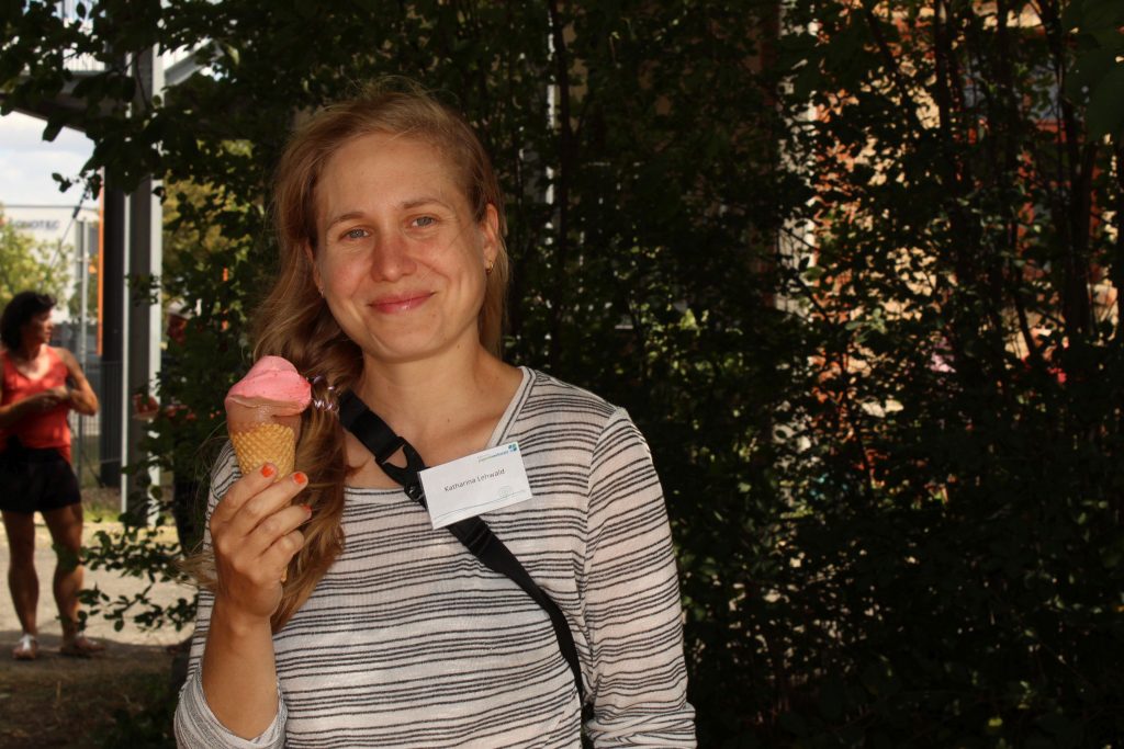 Eine Frau hält ein Eis in der Hand und lächelt