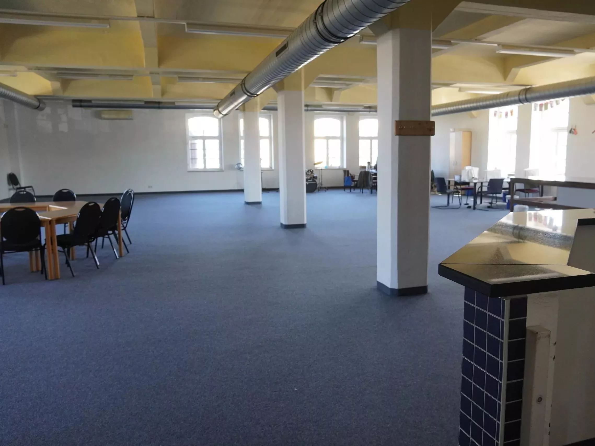 Ein großer Saal mit Tischgruppen