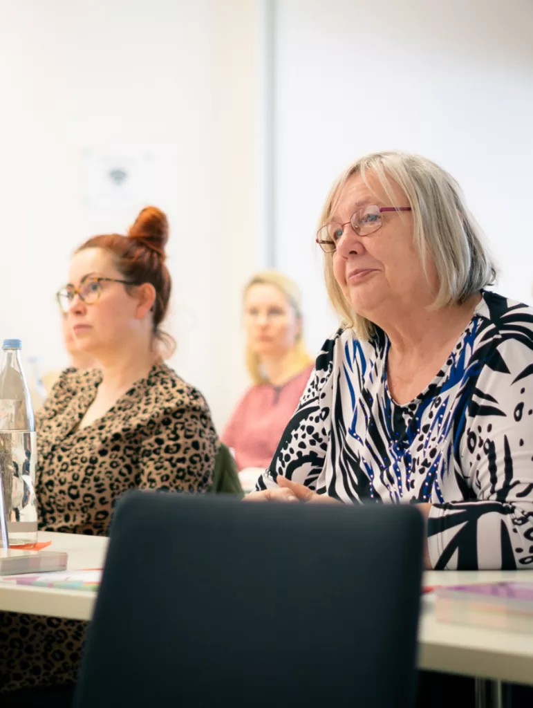 Frauen sitzen an Tischen